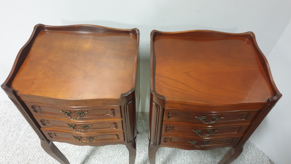 A matching pair of tall French mahogany bedside chests featuring three drawers with brass handles and slender cabriole legs. View VII