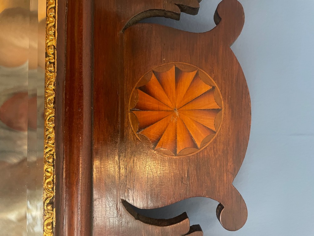 A dark mahogany rectangular wall mirror featuring fretwork scroll cresting with a central inlaid shell motif and a gilded inner frame slip. View II