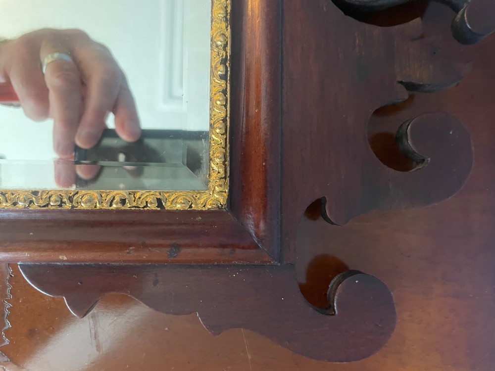 A dark mahogany rectangular wall mirror featuring fretwork scroll cresting with a central inlaid shell motif and a gilded inner frame slip. View III