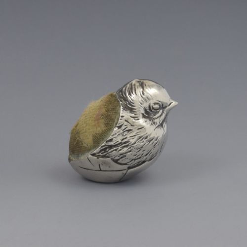 fig 1. An Edwardian sterling silver pin cushion in the shape of a hatching chick emerging from an egg shell with a fabric insert on its back.