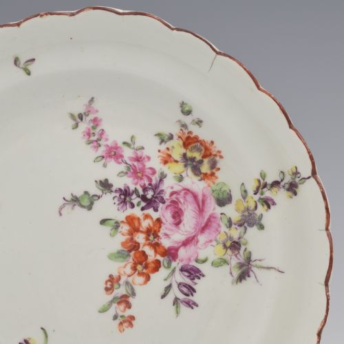 fig 1. An 18th-century English soft-paste porcelain lobed plate decorated with hand-painted polychrome floral sprays and a brown line rim.