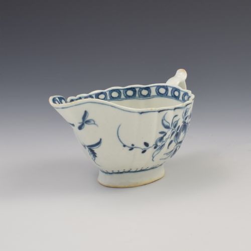 fig 1. An eighteenth-century First Period Worcester blue and white soft-paste porcelain sauce boat featuring hand-painted rose motifs and a moulded body.