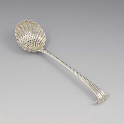 fig 1. An 18th-century sterling silver sifter spoon featuring an Onslow scroll terminal, feather-edge shaft, and a pierced shell bowl.