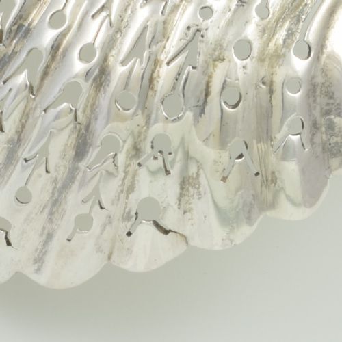 An 18th-century sterling silver sifter spoon featuring an Onslow scroll terminal, feather-edge shaft, and a pierced shell bowl. View XII