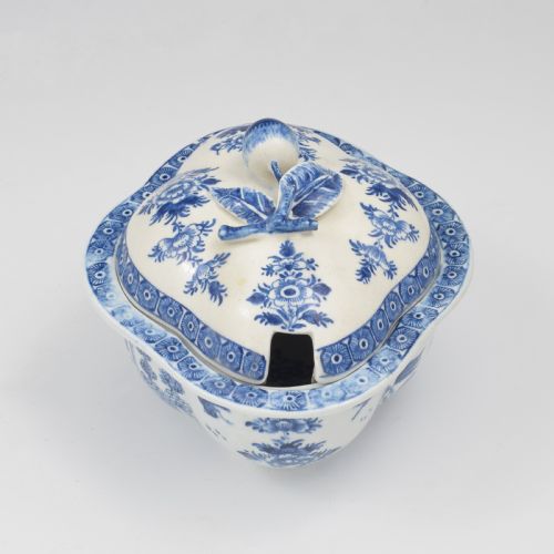 fig 1. An eighteenth-century Derby soft-paste porcelain sauce tureen and cover featuring a quatrefoil shape, hand-painted blue and white Chinoiserie decoration, and a sculpted fruit handle on the lid.