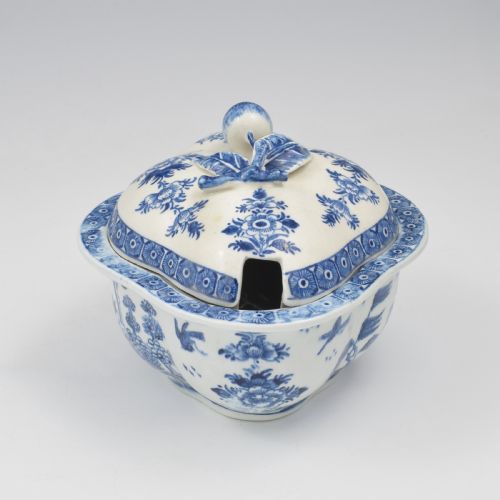 fig 2. An eighteenth-century Derby soft-paste porcelain sauce tureen and cover featuring a quatrefoil shape, hand-painted blue and white Chinoiserie decoration, and a sculpted fruit handle on the lid.