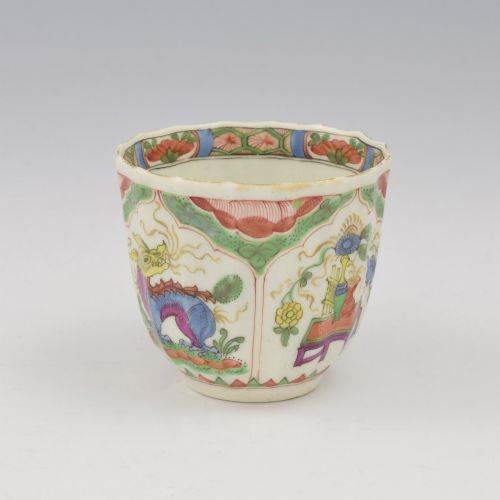 fig 1. An 18th-century fluted soft-paste porcelain coffee cup with hand-painted Chinoiserie dragon motifs and a looped handle.