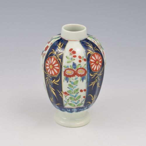 fig 1. A First Period Worcester soft-paste porcelain tea canister decorated with cobalt blue panels, gilt scrolls, and polychrome floral reserves.