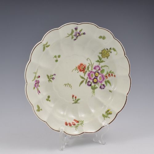 fig 1. An 18th-century lobed soft-paste porcelain plate decorated with hand-painted polychrome floral sprays and a brown line rim.