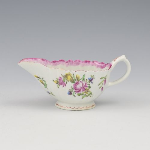 fig 1. An eighteenth-century Bow soft-paste porcelain fluted sauce boat with hand-painted floral sprigs and a magenta feathered rim.