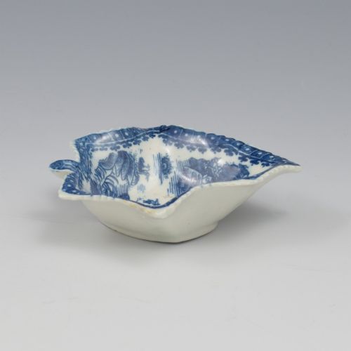 fig 1. An 18th-century blue and white Caughley soft-paste porcelain pickle dish shaped like a leaf with a serrated rim and printed with a Oriental landscape pattern.