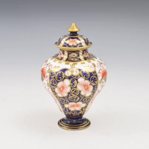 A baluster-shaped porcelain miniature vase and matching domed lid decorated with a cobalt blue, iron red, and gilt Imari pattern. View V
