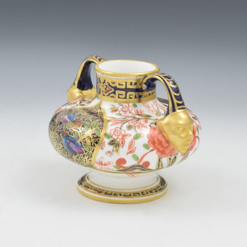 fig 2. A Victorian Royal Crown Derby porcelain vase featuring twin gilded mask handles, intricate cobalt blue and gold panel decoration, and hand-painted floral motifs.