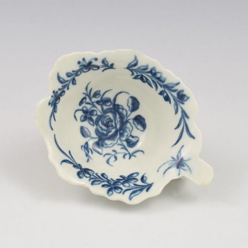 fig 1. A leaf-shaped soft-paste porcelain butter boat decorated with an underglaze blue hand-painted rose motif and a floral running border.