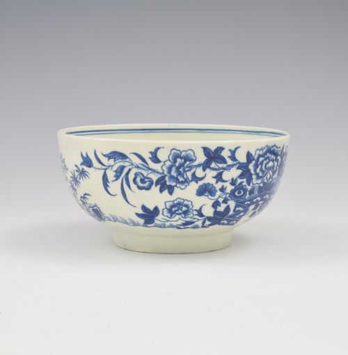 fig 1. An 18th-century blue and white soft-paste porcelain slop bowl decorated with the oriental fence pattern and floral motifs.