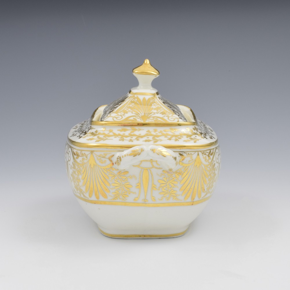 A white and gold Regency Spode porcelain sugar box with original lid, featuring loop handles and Neoclassical gilt scroll patterning. View VI