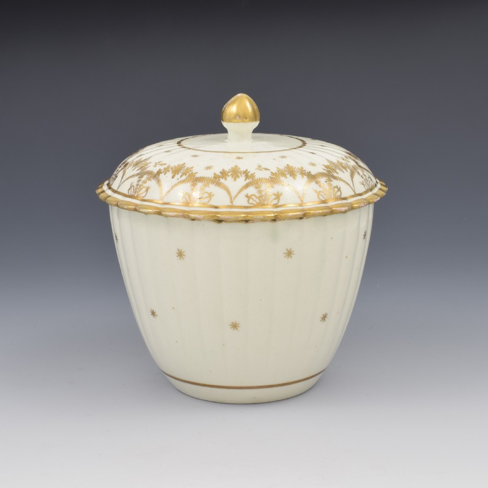 An eighteenth-century fluted cream porcelain sucrier and fitted cover adorned with gold gilded swags and star motifs. View II
