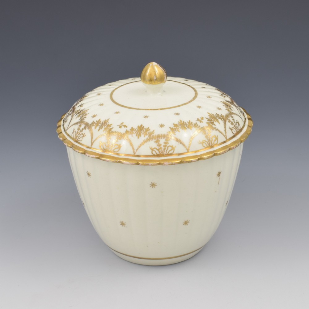 An eighteenth-century fluted cream porcelain sucrier and fitted cover adorned with gold gilded swags and star motifs. View III