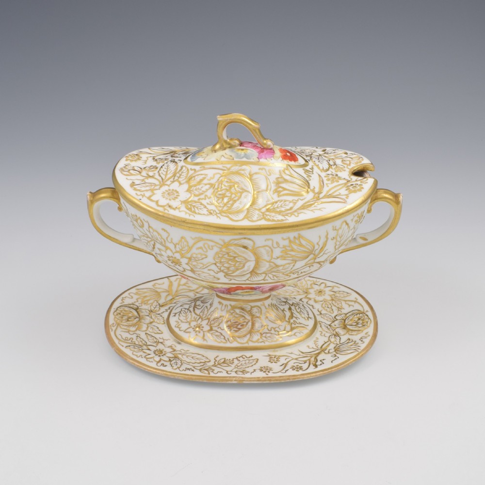 A Regency era white porcelain sauce tureen featuring gilded floral designs, hand-painted botanical flowers, twin side handles, and a matching stand. View IV