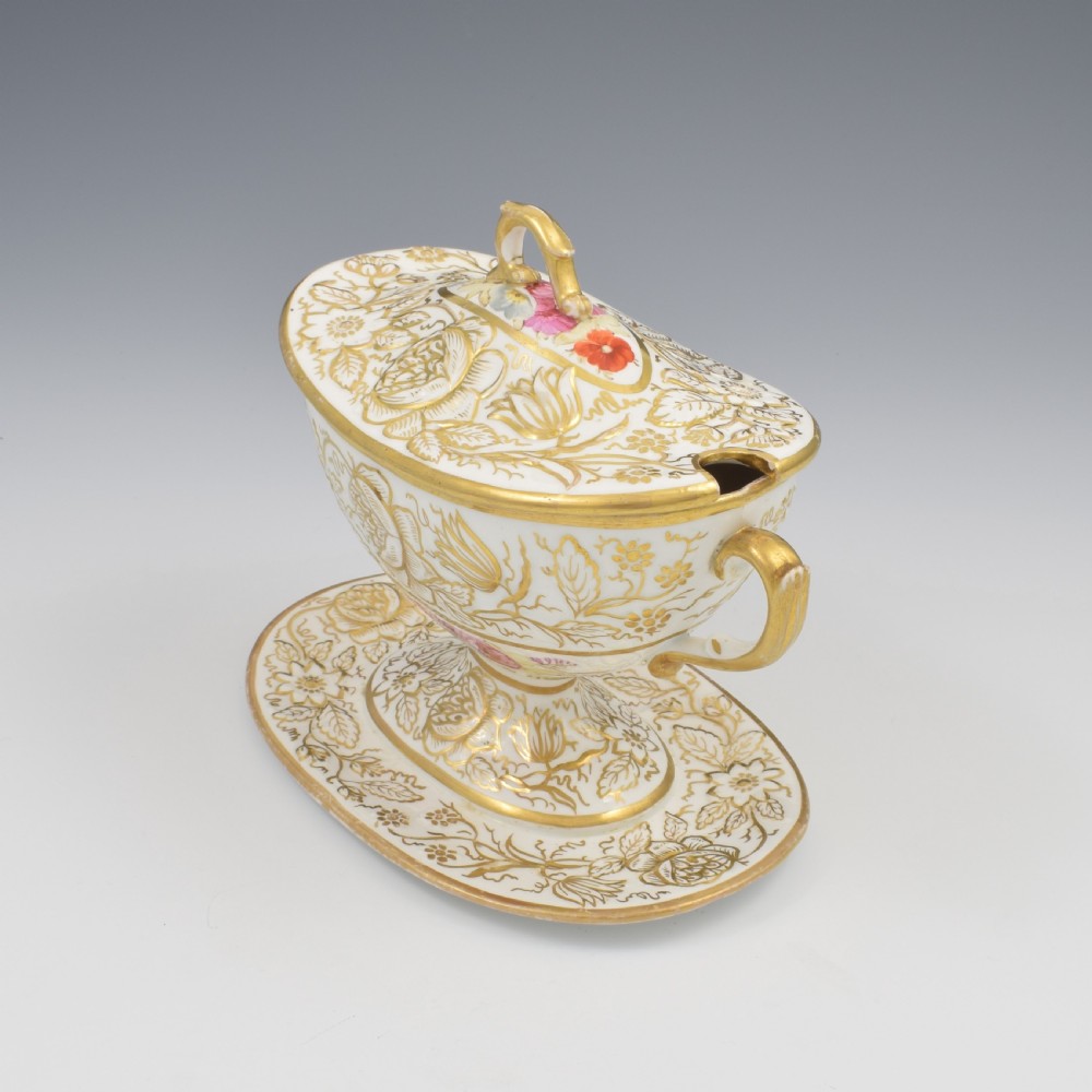 A Regency era white porcelain sauce tureen featuring gilded floral designs, hand-painted botanical flowers, twin side handles, and a matching stand. View V