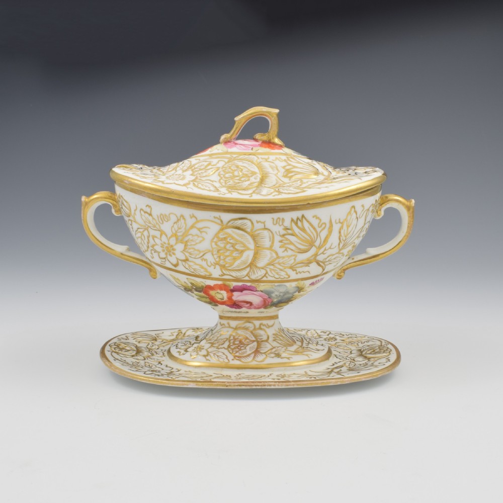 A Regency era white porcelain sauce tureen featuring gilded floral designs, hand-painted botanical flowers, twin side handles, and a matching stand. View XIII