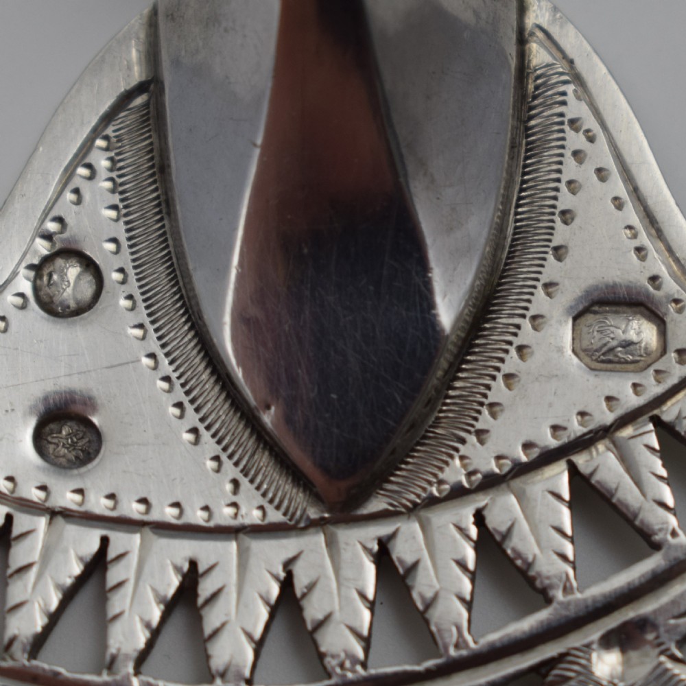 An 18th-century French silver fish slice with a pierced geometric lattice blade, an engraved crest, and a turned dark wood handle. View XV