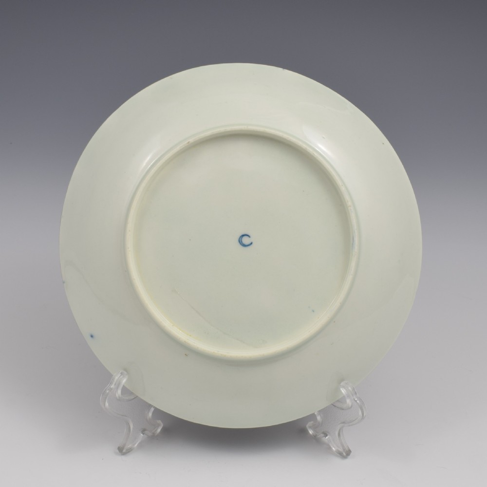 An eighteenth-century circular porcelain saucer dish featuring a deep cobalt blue border with gilt scrollwork and a white central medallion containing hand-painted exotic birds. View IV