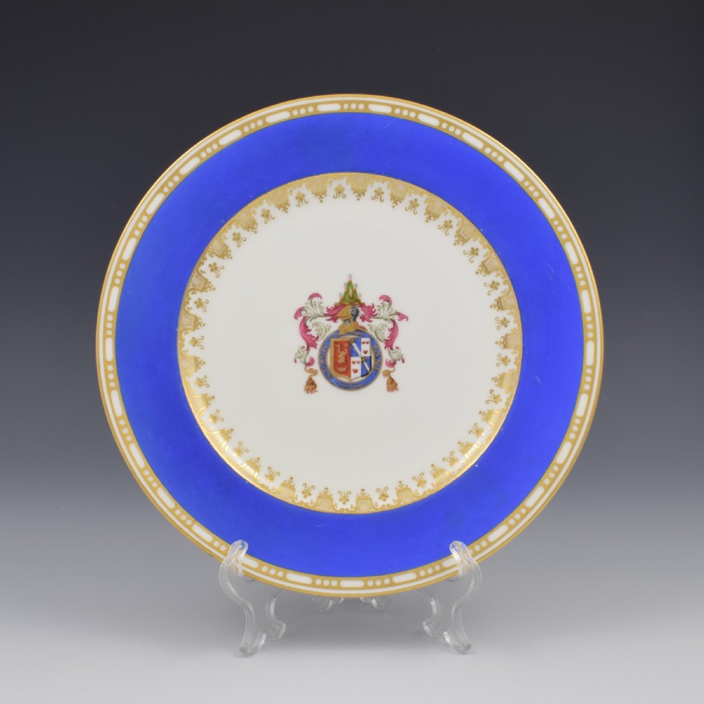 A Victorian Copeland porcelain cabinet plate featuring a bright cobalt blue border, gilt ornamentation, and a central heraldic coat of arms on a white ceramic ground.
