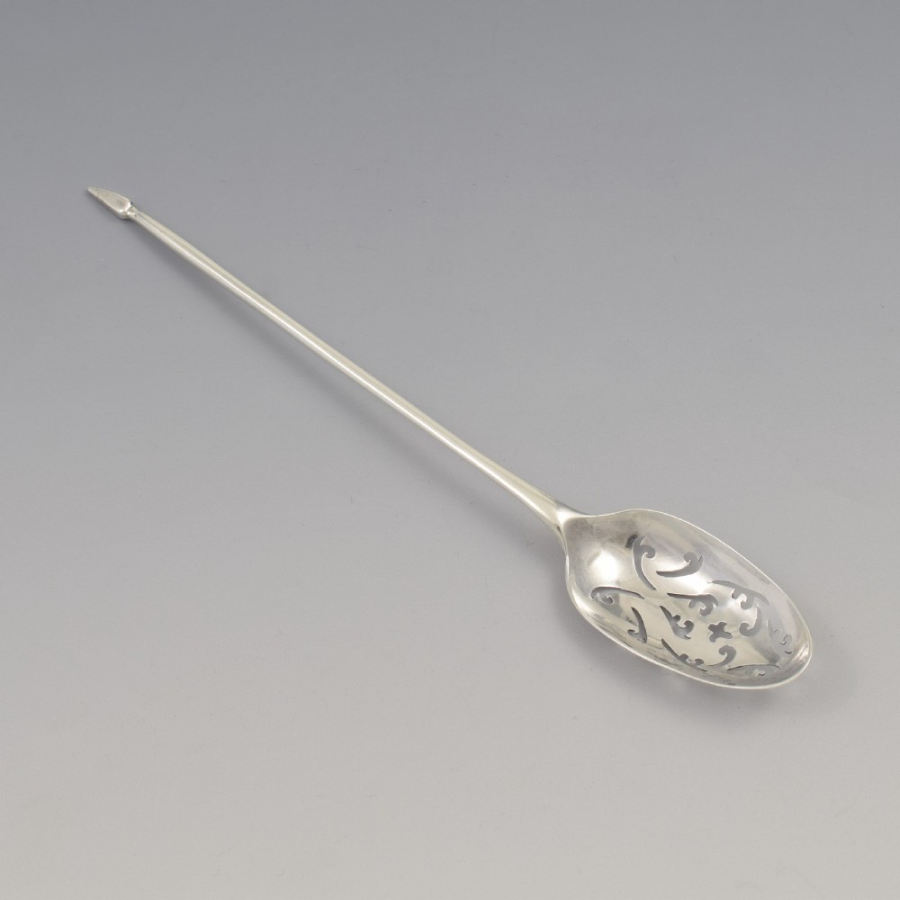 A George II sterling silver mote spoon with a pierced scrollwork bowl and a slender stem terminating in a pointed tip. View II