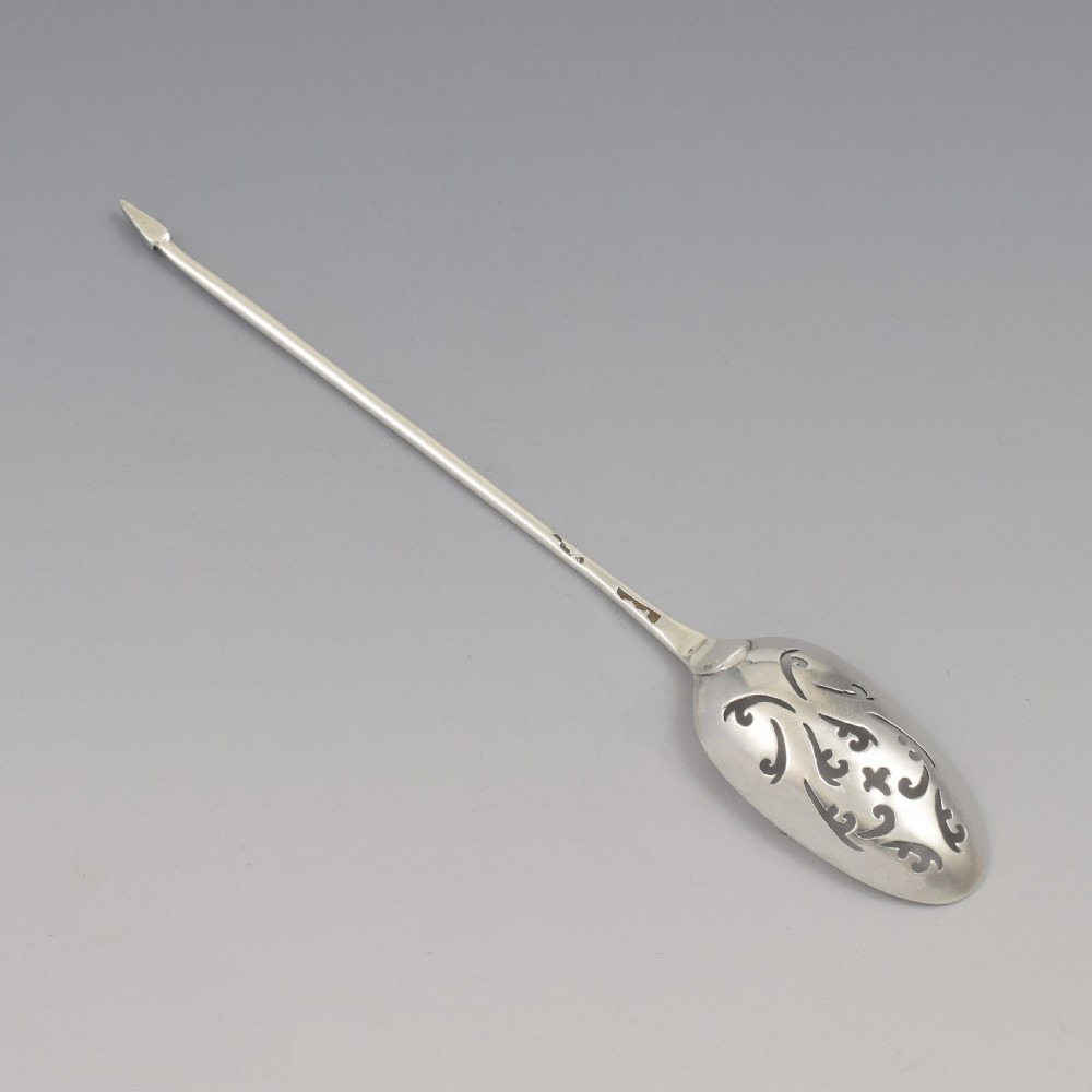 A George II sterling silver mote spoon with a pierced scrollwork bowl and a slender stem terminating in a pointed tip. View VI