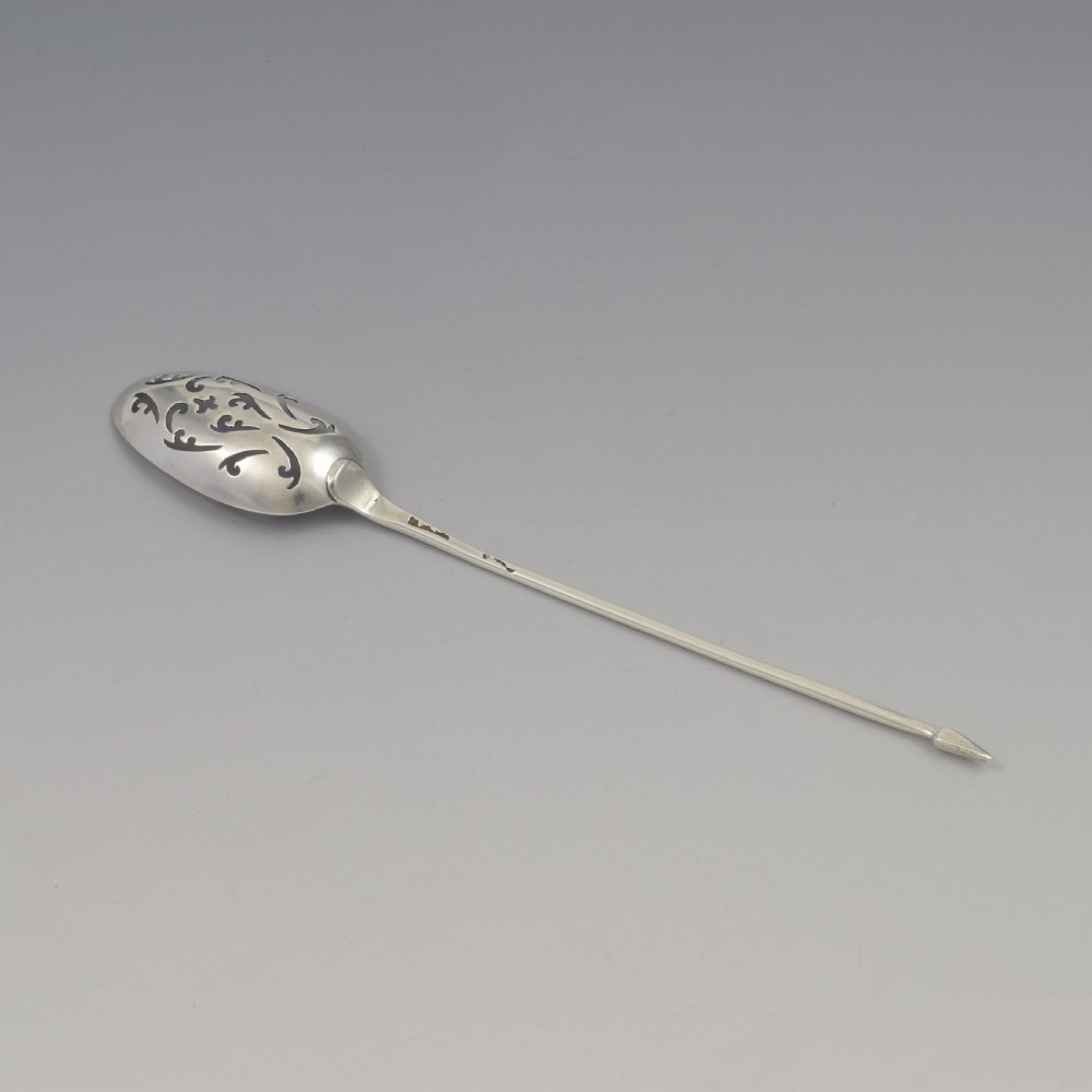 A George II sterling silver mote spoon with a pierced scrollwork bowl and a slender stem terminating in a pointed tip. View VIII