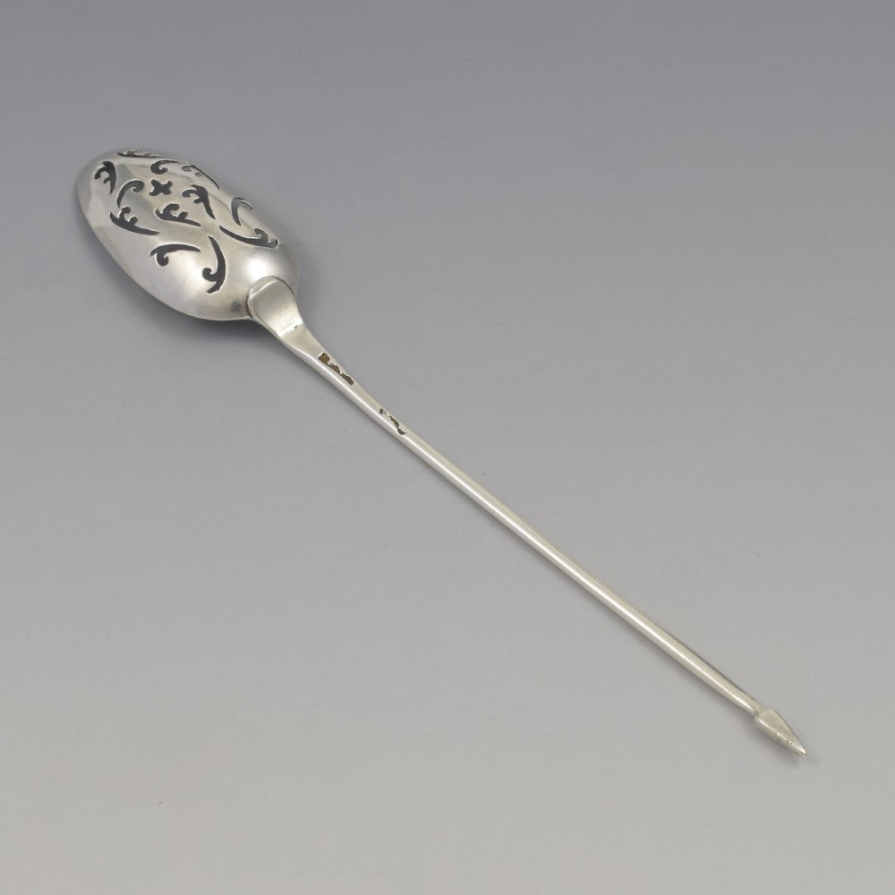 A George II sterling silver mote spoon with a pierced scrollwork bowl and a slender stem terminating in a pointed tip. View IX