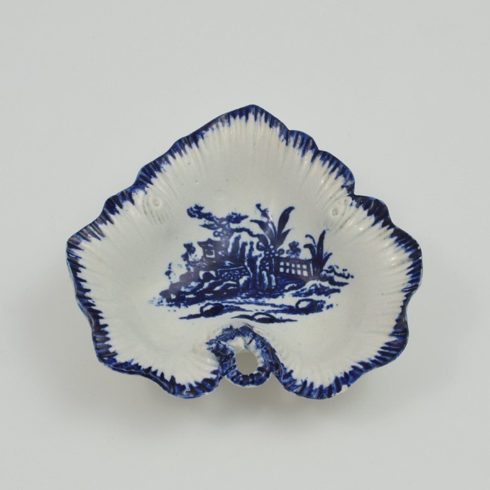 A leaf-shaped 18th-century Liverpool soft-paste porcelain pickle dish decorated with an underglaze blue chinoiserie landscape and feathered blue rim. View II