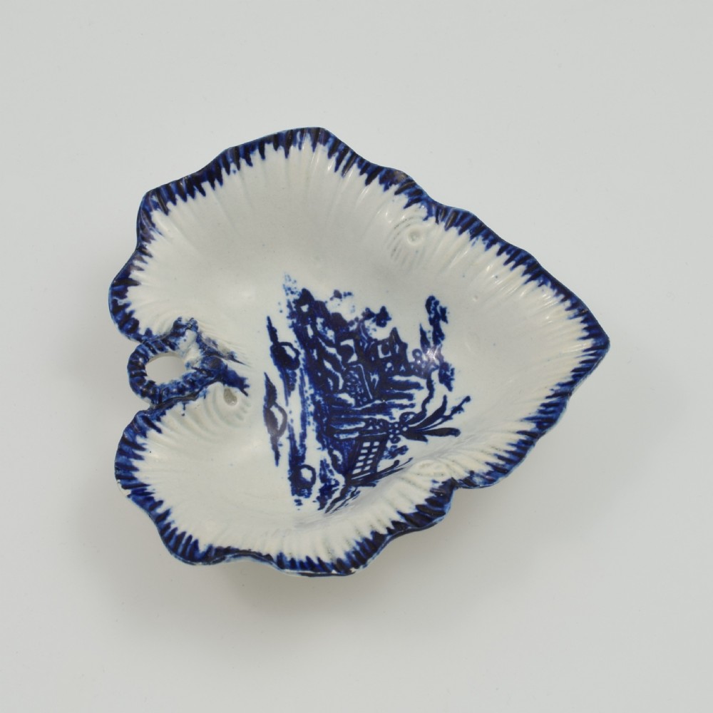 A leaf-shaped 18th-century Liverpool soft-paste porcelain pickle dish decorated with an underglaze blue chinoiserie landscape and feathered blue rim. View V