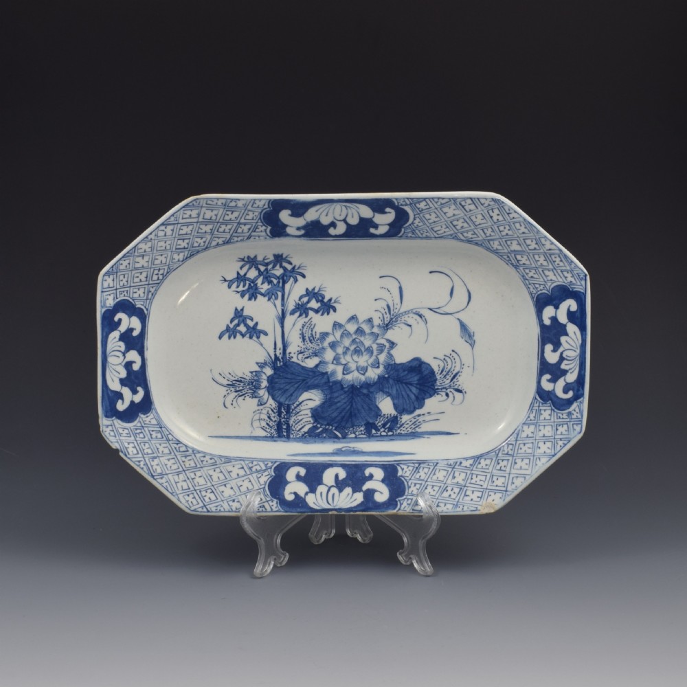 An 18th-century octagonal blue and white soft-paste porcelain serving dish decorated with a central lotus and bamboo design within a diaper border.
