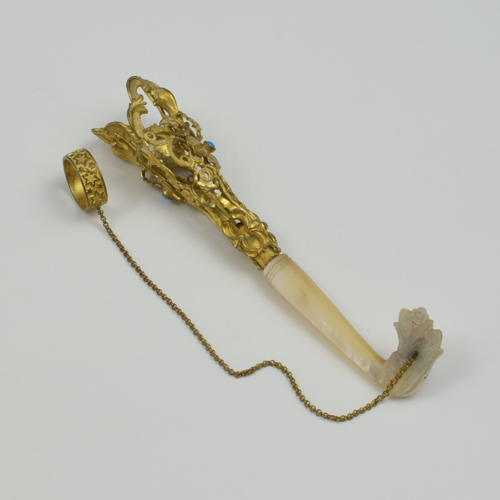An antique French gilt ormolu tussie mussie posy holder featuring elaborate pierced metalwork set with a turquoise stone, a carved mother-of-pearl handle, and a finger ring attached by a chain. View II