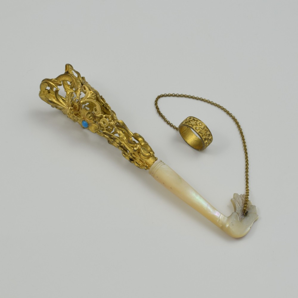 An antique French gilt ormolu tussie mussie posy holder featuring elaborate pierced metalwork set with a turquoise stone, a carved mother-of-pearl handle, and a finger ring attached by a chain. View III