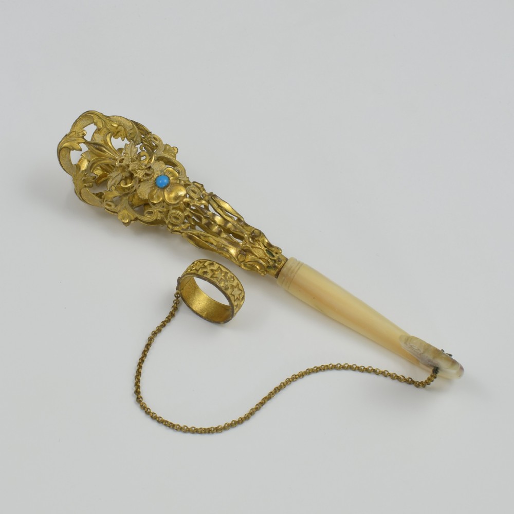 An antique French gilt ormolu tussie mussie posy holder featuring elaborate pierced metalwork set with a turquoise stone, a carved mother-of-pearl handle, and a finger ring attached by a chain. View XIII