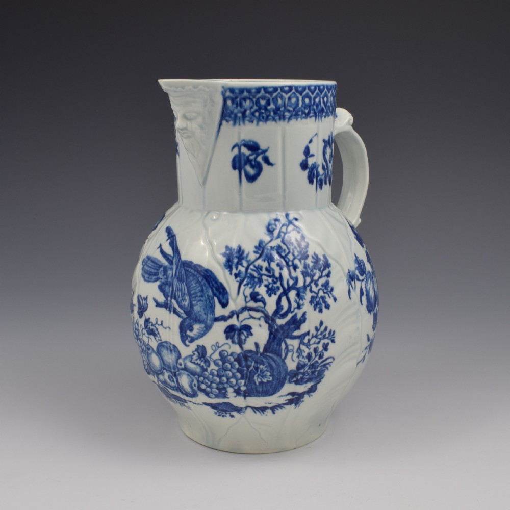 An 18th-century First Period Worcester soft-paste porcelain mask jug featuring cabbage-leaf moulding and blue and white printed foliage motifs. View II