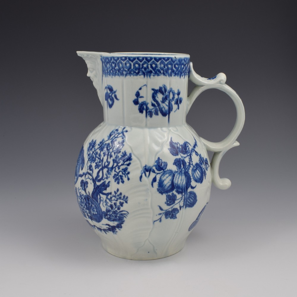 An 18th-century First Period Worcester soft-paste porcelain mask jug featuring cabbage-leaf moulding and blue and white printed foliage motifs. View III