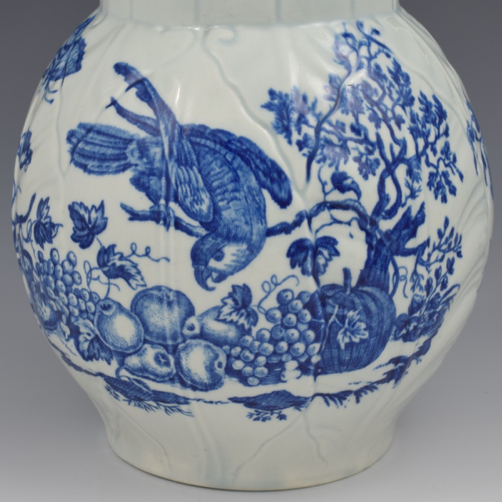 An 18th-century First Period Worcester soft-paste porcelain mask jug featuring cabbage-leaf moulding and blue and white printed foliage motifs. View VIII