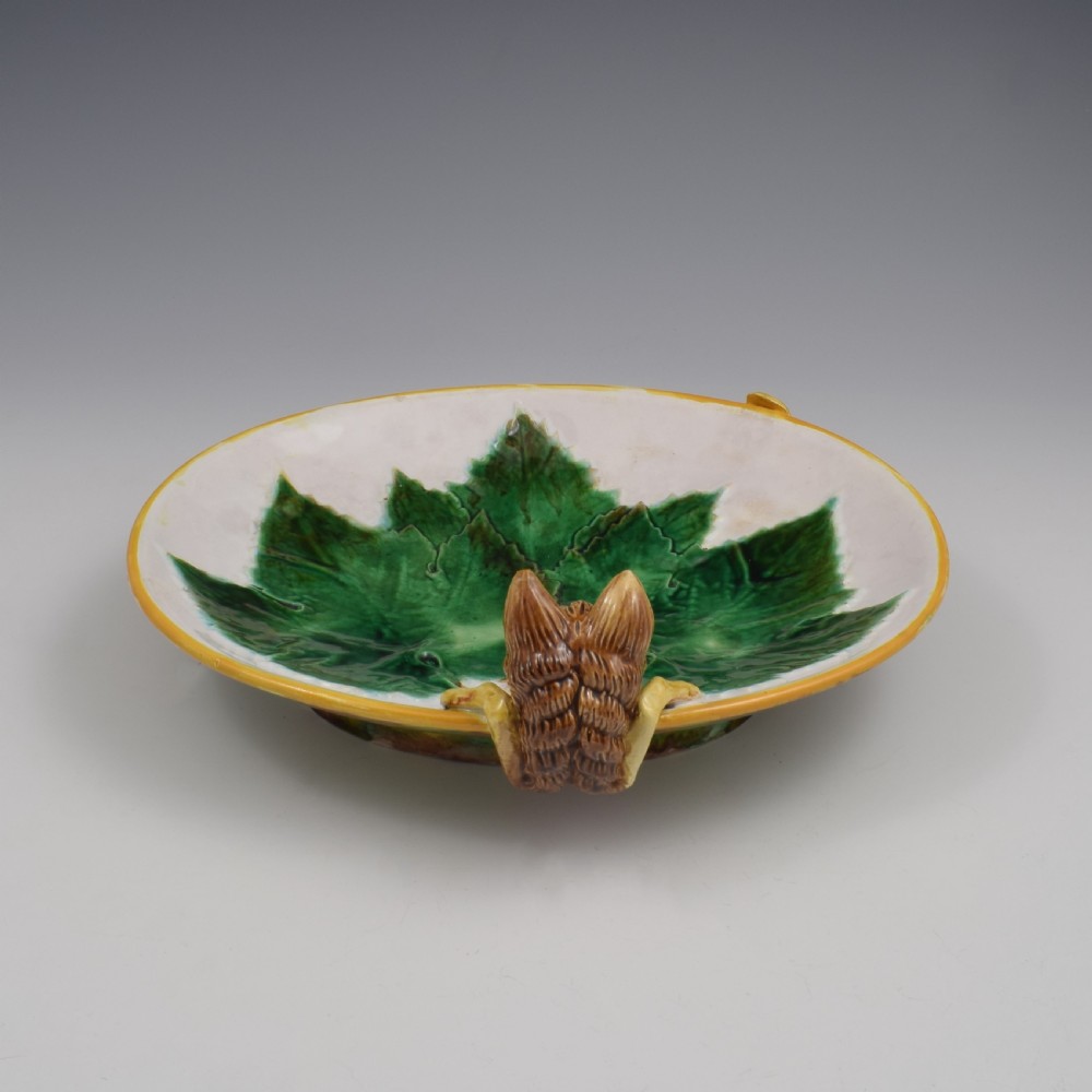 An oval Victorian majolica dish featuring a pink interior ground with raised green leaves and a sculpted fox head perched on the rim. View VI