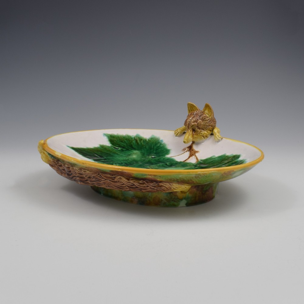 An oval Victorian majolica dish featuring a pink interior ground with raised green leaves and a sculpted fox head perched on the rim. View X