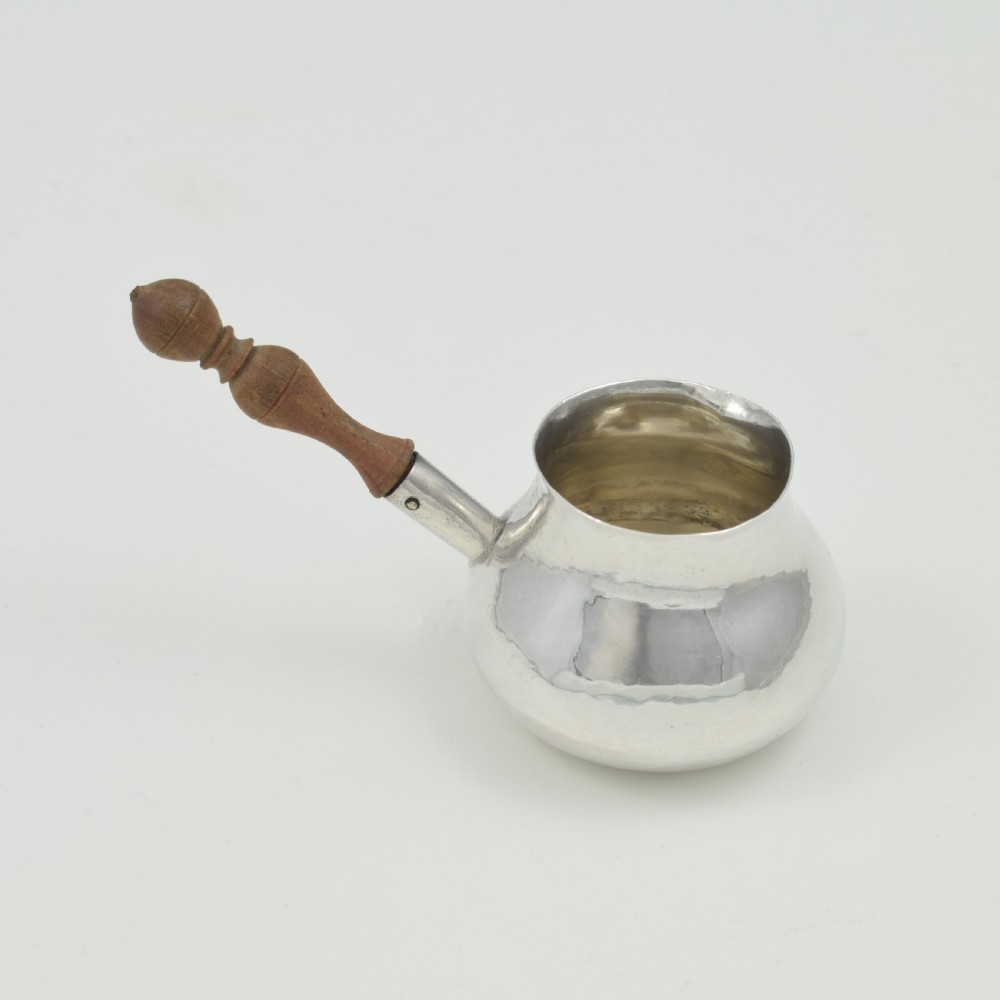 A miniature George I sterling silver brandy warming pan featuring a bulbous body, small spout, and a turned wooden handle. View VIII