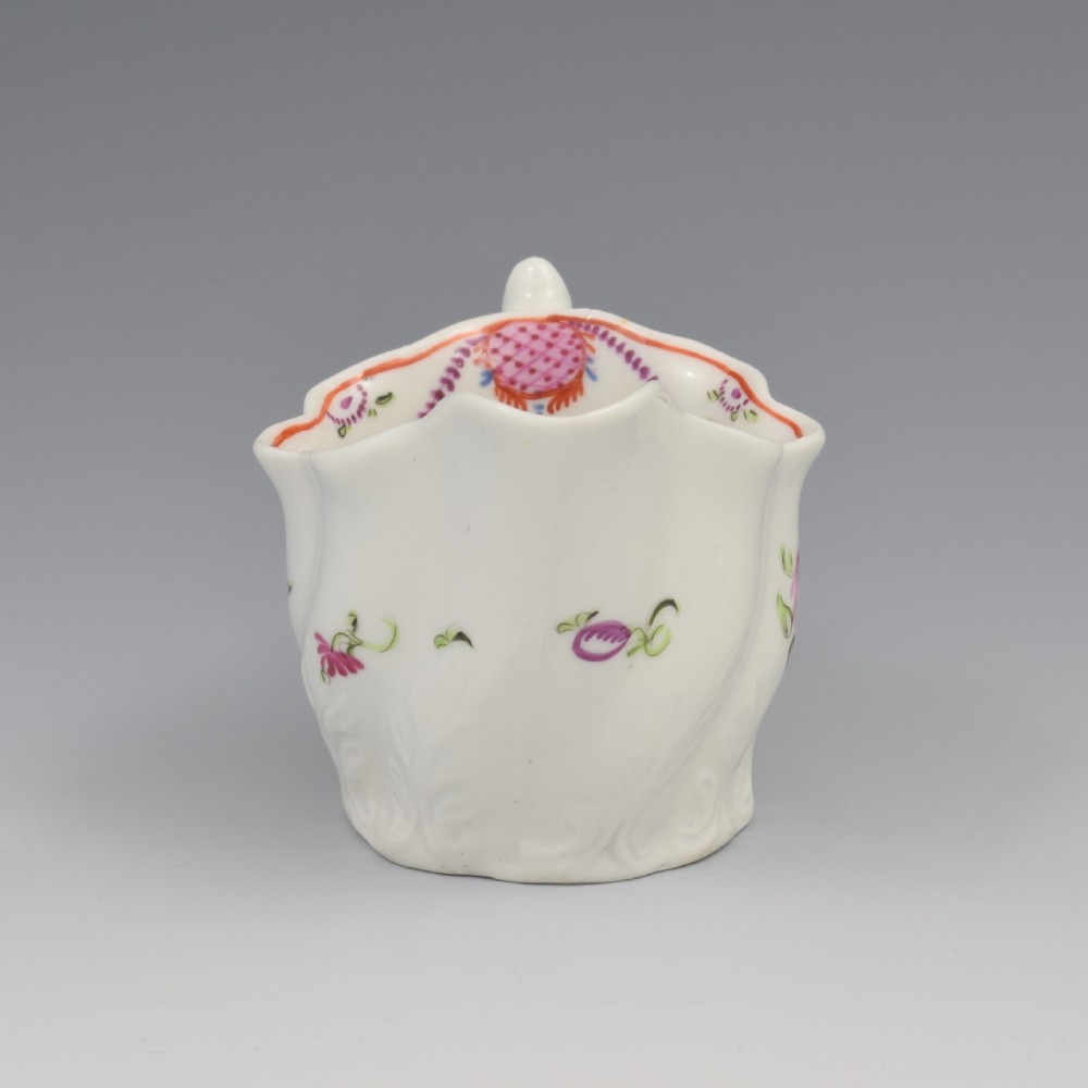 A white porcelain low Chelsea ewer cream jug featuring hand-painted pink floral sprigs, a moulded leaf base, and an ornate loop handle. View III