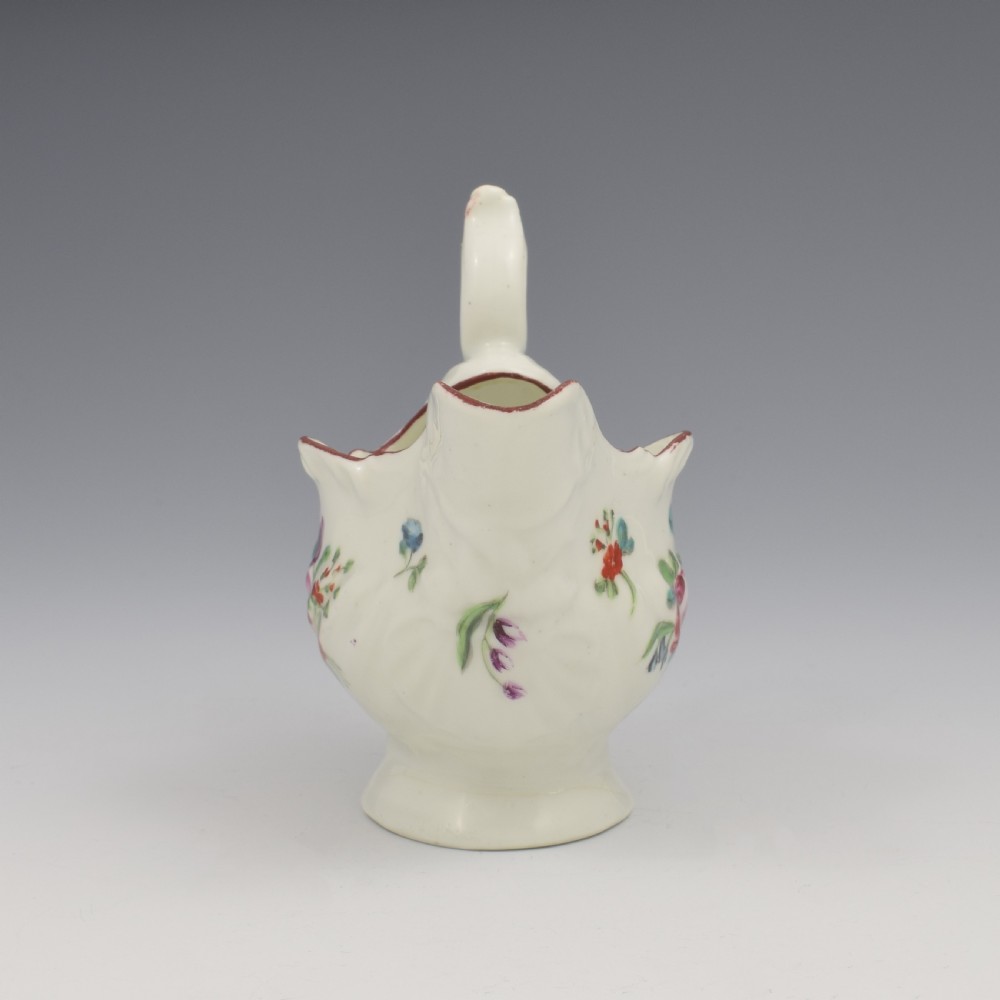 A Georgian Derby soft-paste porcelain cream boat with hand-painted floral motifs and a shaped loop handle on a pedestal base. View III