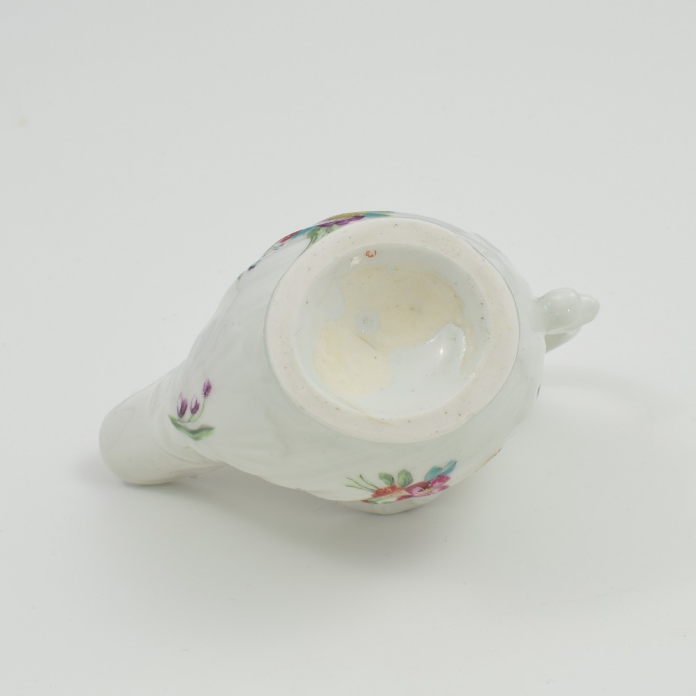 A Georgian Derby soft-paste porcelain cream boat with hand-painted floral motifs and a shaped loop handle on a pedestal base. View IX