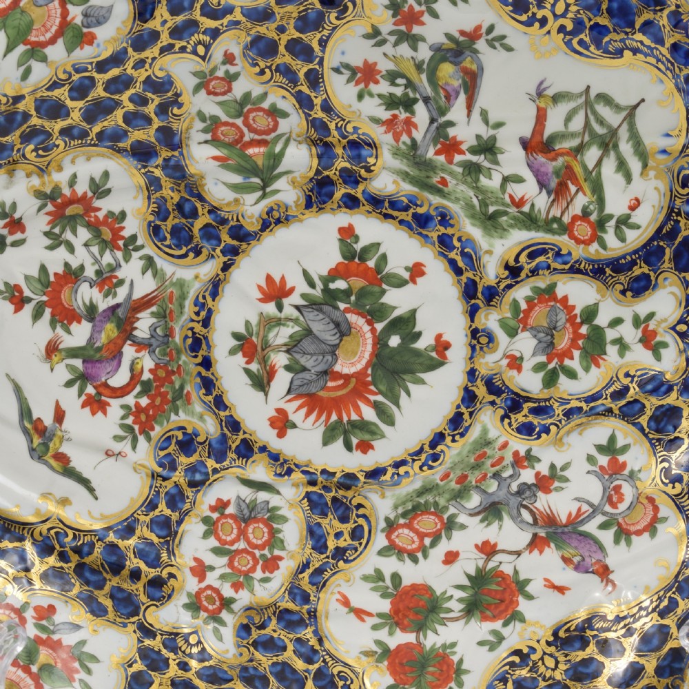 An eighteenth-century Worcester soft-paste porcelain leaf-shaped dish decorated with dark blue cailloute ground, gilded reserves, and hand-painted Kakiemon floral and bird motifs. View III