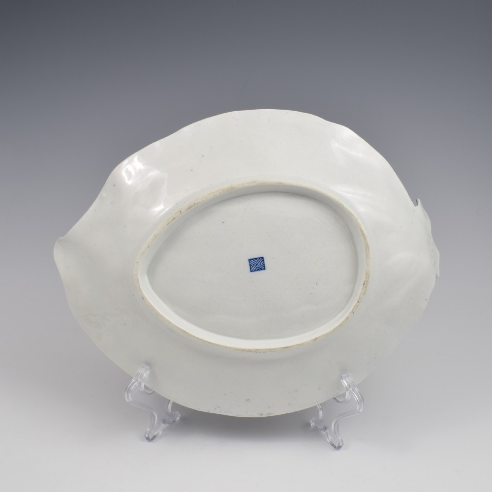 An eighteenth-century Worcester soft-paste porcelain leaf-shaped dish decorated with dark blue cailloute ground, gilded reserves, and hand-painted Kakiemon floral and bird motifs. View VIII