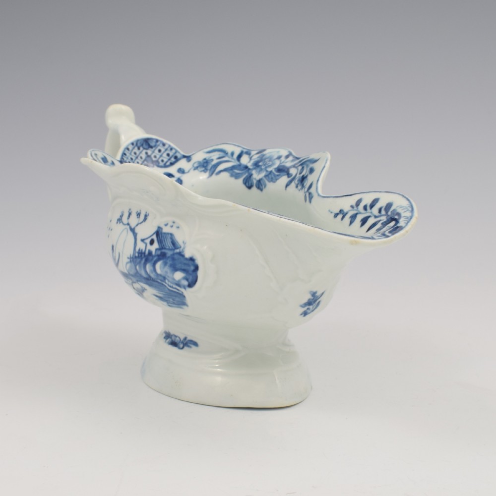 An 18th-century First Period Worcester soft-paste porcelain sauce boat decorated with a hand-painted blue and white chinoiserie landscape motif. View II